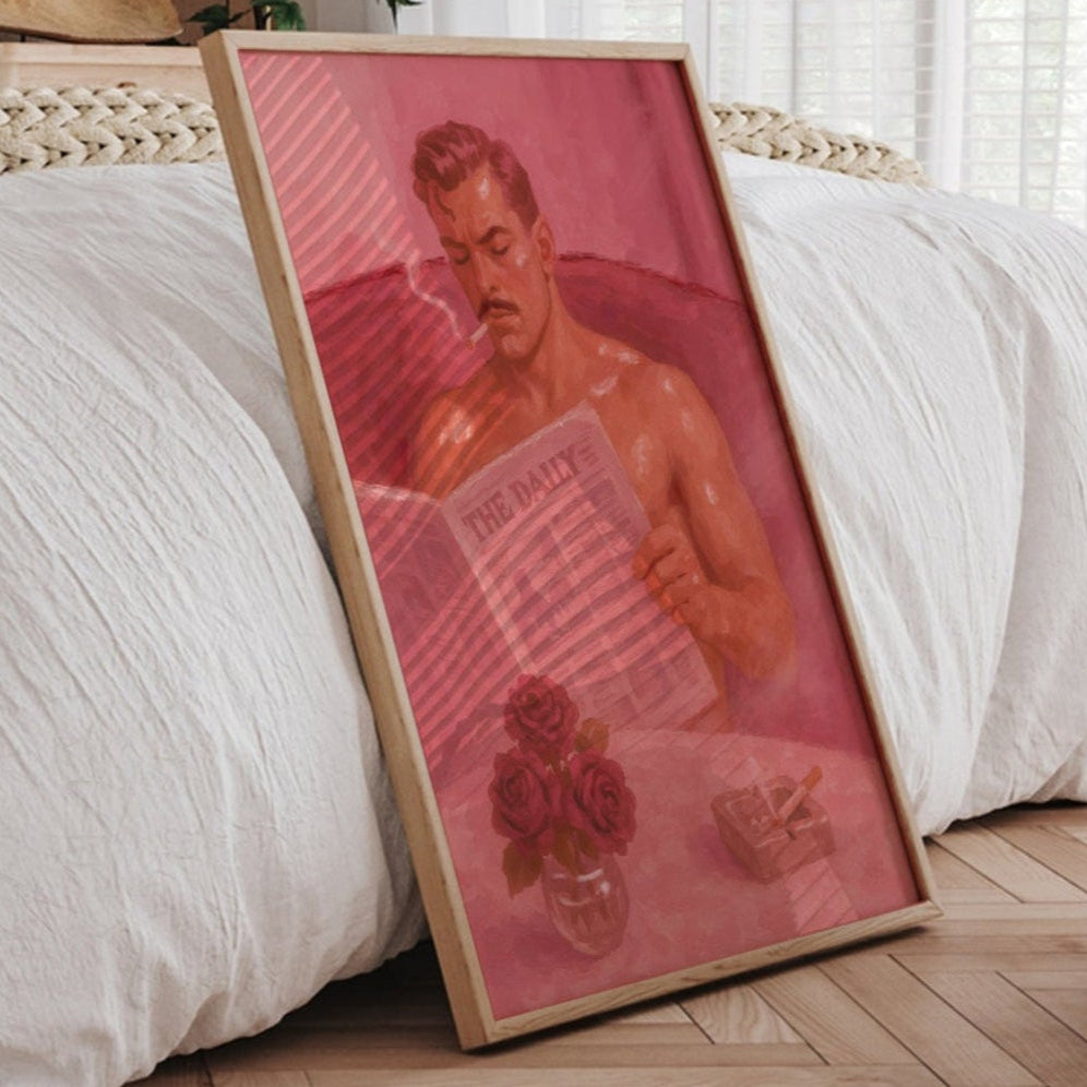 Framed artwork leaning against a bed in a bedroom with natural light