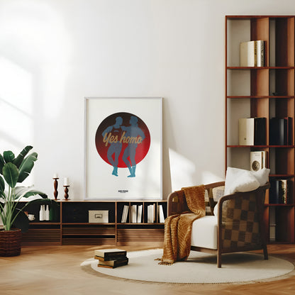 A framed art print featuring a red and blue circular graphic with the words 'Yes homo' is displayed on a wall in a modern, sunlit living room setting next to a wooden bookshelf and checkered armchair.
