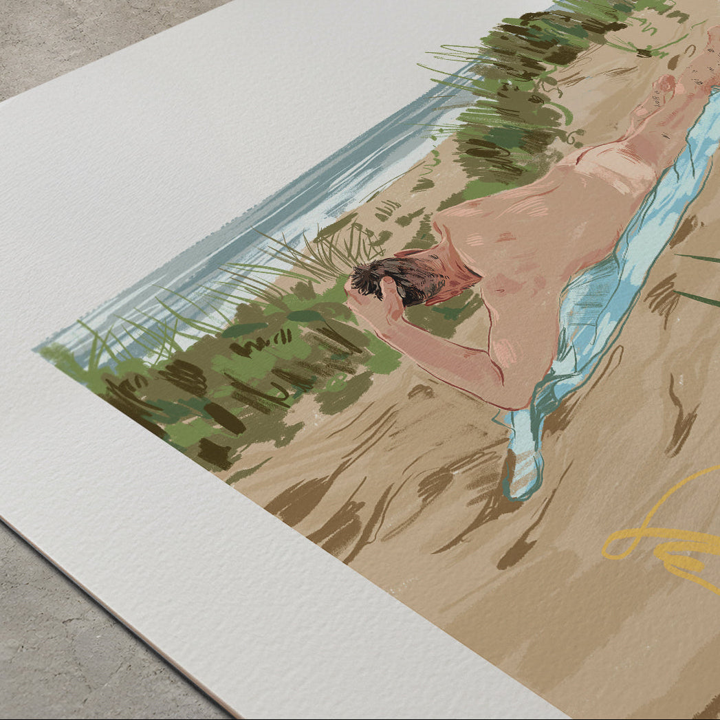 A large art print or poster displayed on a concrete floor, featuring a stylized illustration of a nude man lying on a sandy beach with green vegetation and blue water.