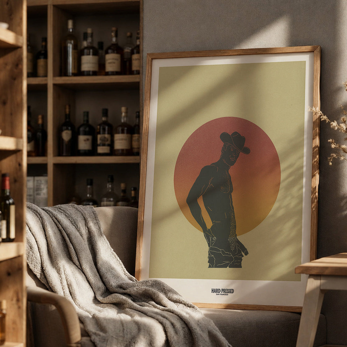 Framed artwork of a silhouette against a sunset background in a cozy room with shelves and decor.