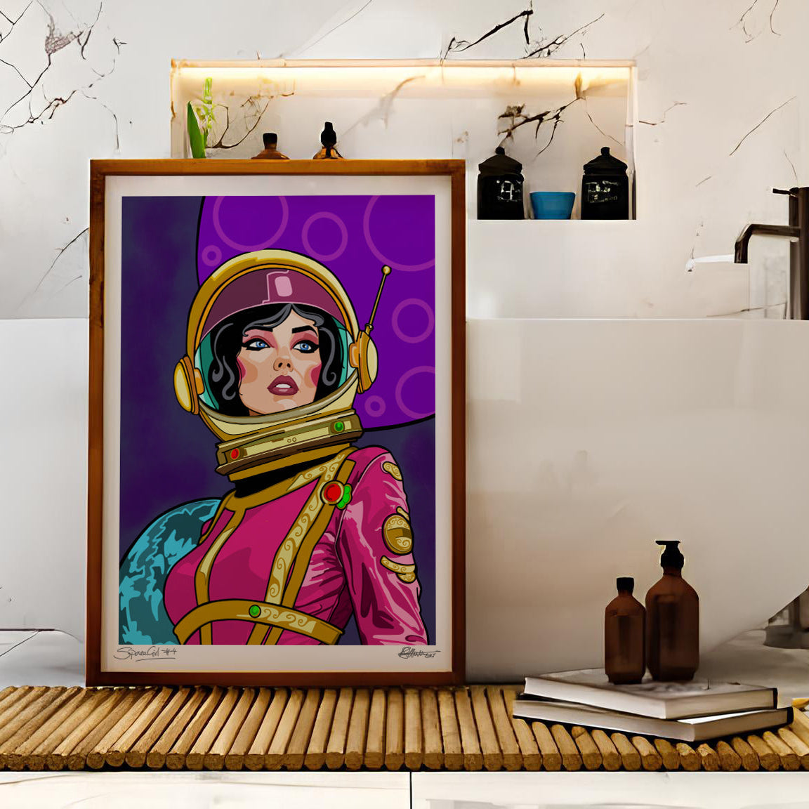 A framed pop-art print of a retro space-themed woman in a pink and purple space suit, displayed on a bamboo mat in front of a white freestanding bathtub in a marble bathroom.
